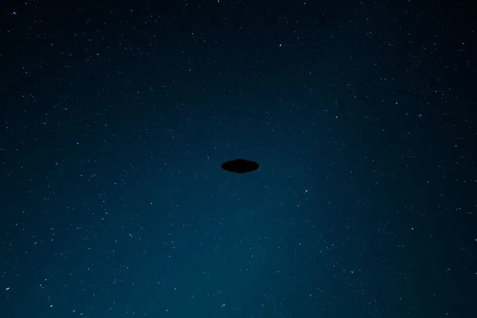 Céu estrelado com um OVNI pairando.