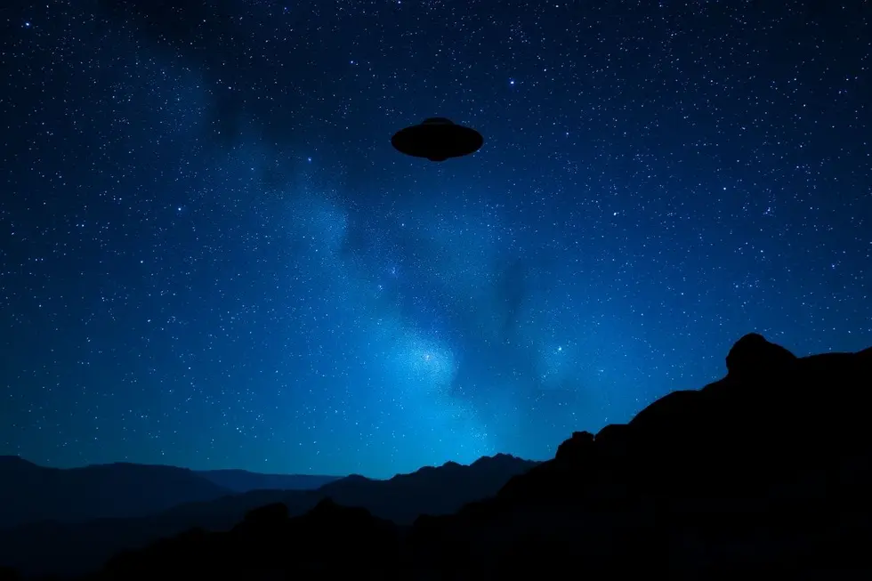 Um céu cheio de estrelas com a silhueta de um OVNI ao fundo.