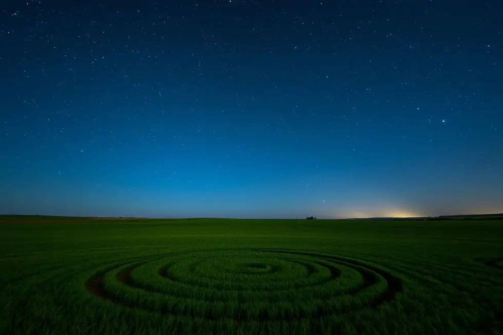 Imagem noturna de um campo com Crop Circles sob um céu estrelado.