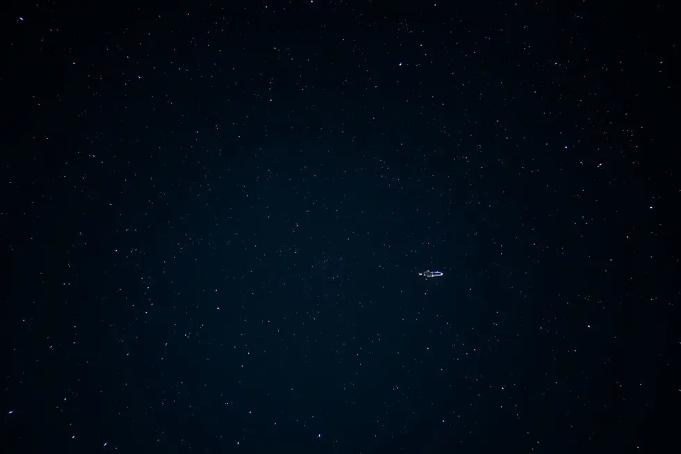 Céu noturno estrelado com uma representação sutil de uma nave espacial.