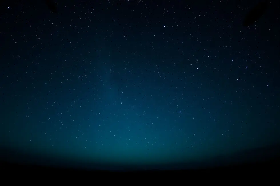 Céu noturno estrelado com formas misteriosas.
