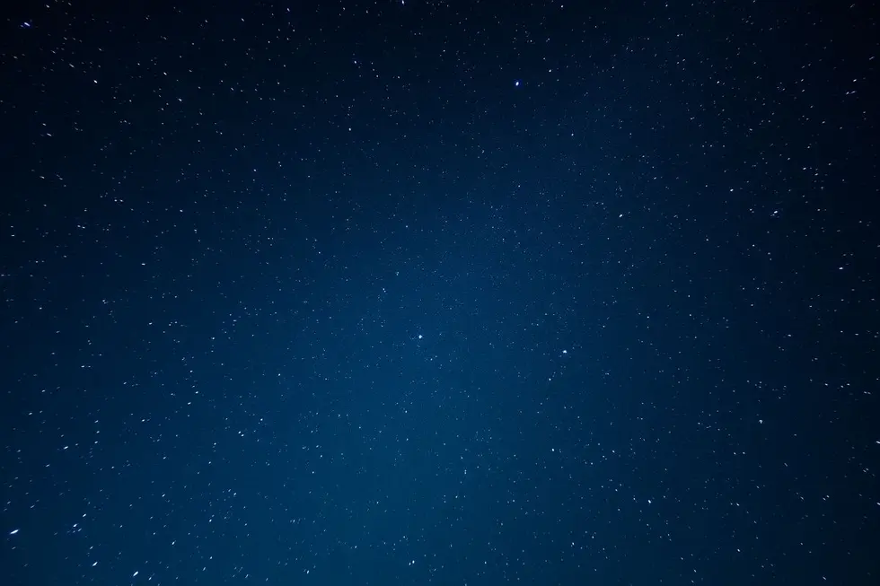 Um céu noturno bonito cheio de estrelas vibrantes e luz na horizontal.
